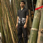 Zoomed in Side details of Soham in a black linen shirt standing in a bamboo shop