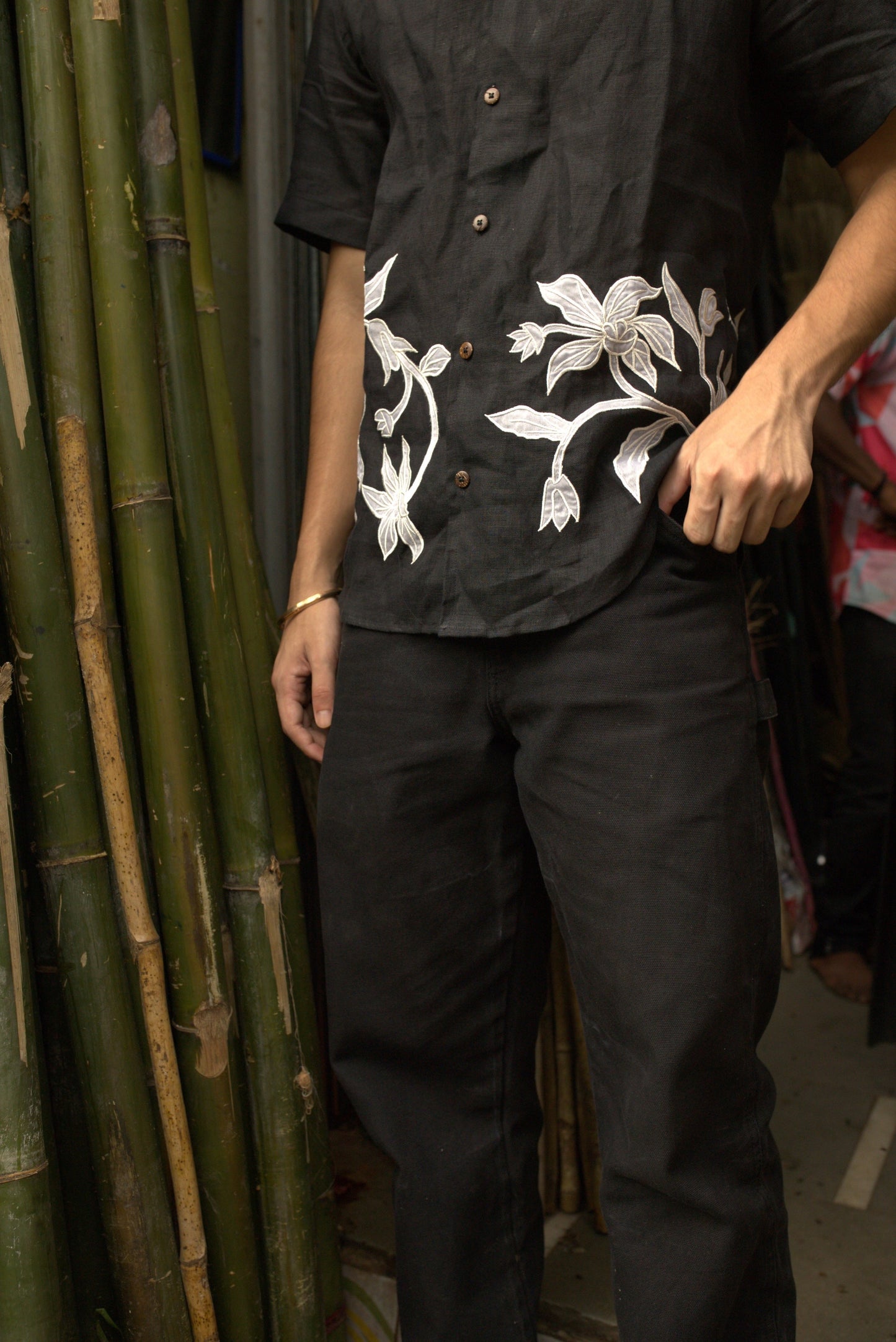 Details of a black linen shirt with silk lilies cut and stitched with the patchwork technique