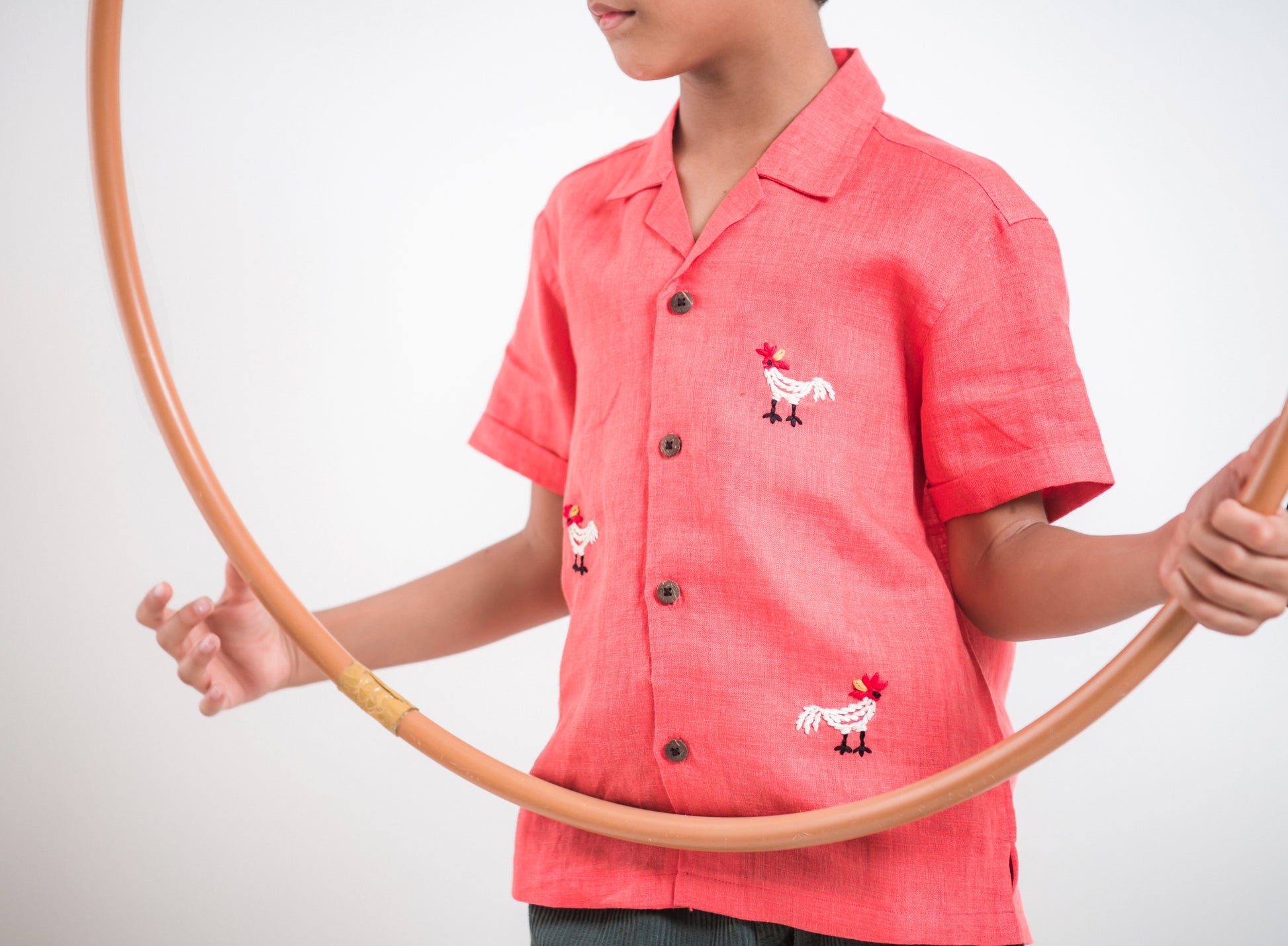 Details of a red linen shirt with embroidered roosters