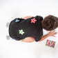 details of the back of a young 5-6 year old boy in a floral black linen shirt sitting and reading