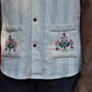 Details of an off-white cotton shirt with embroidered pockets