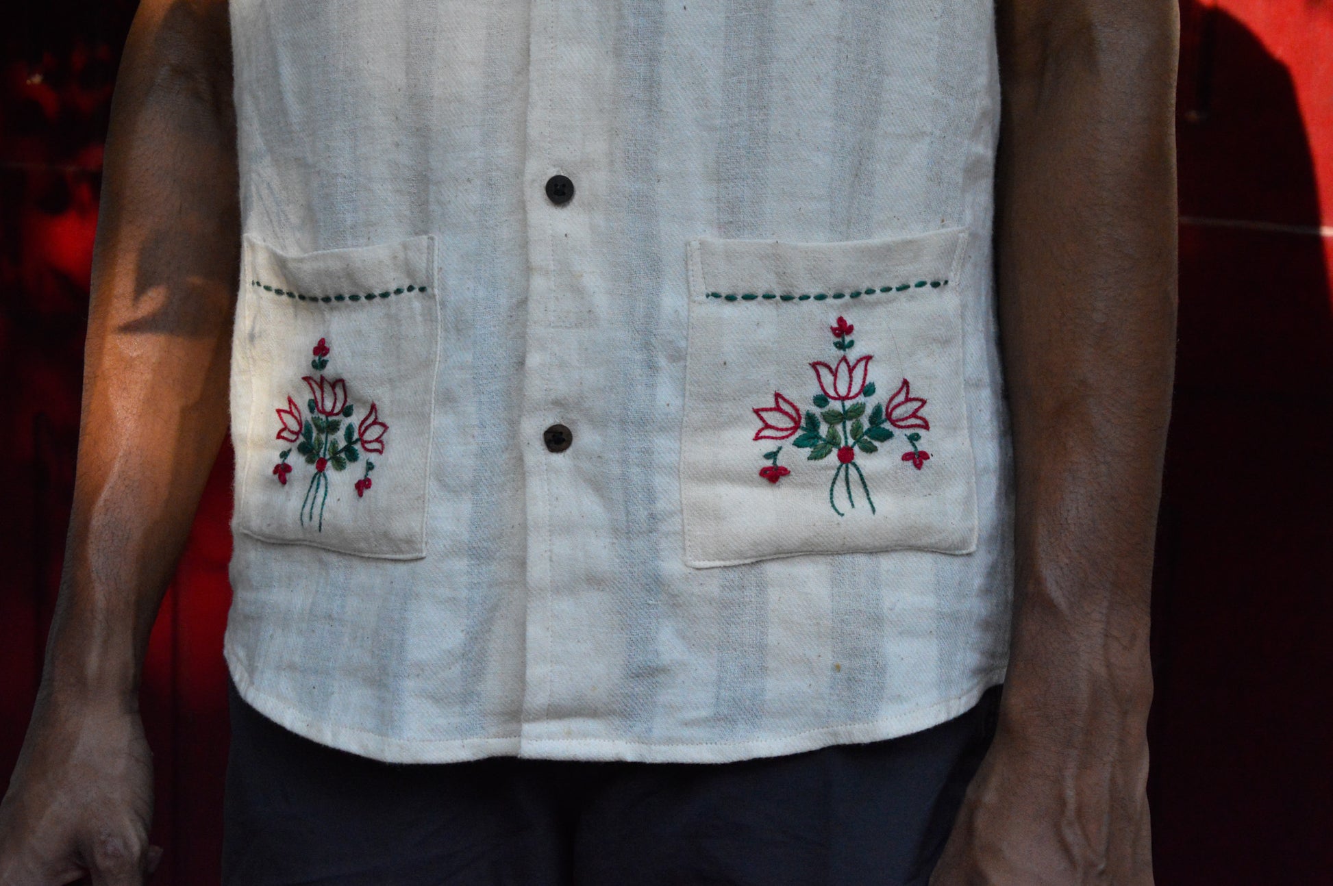 Details of an off-white cotton shirt with embroidered pockets