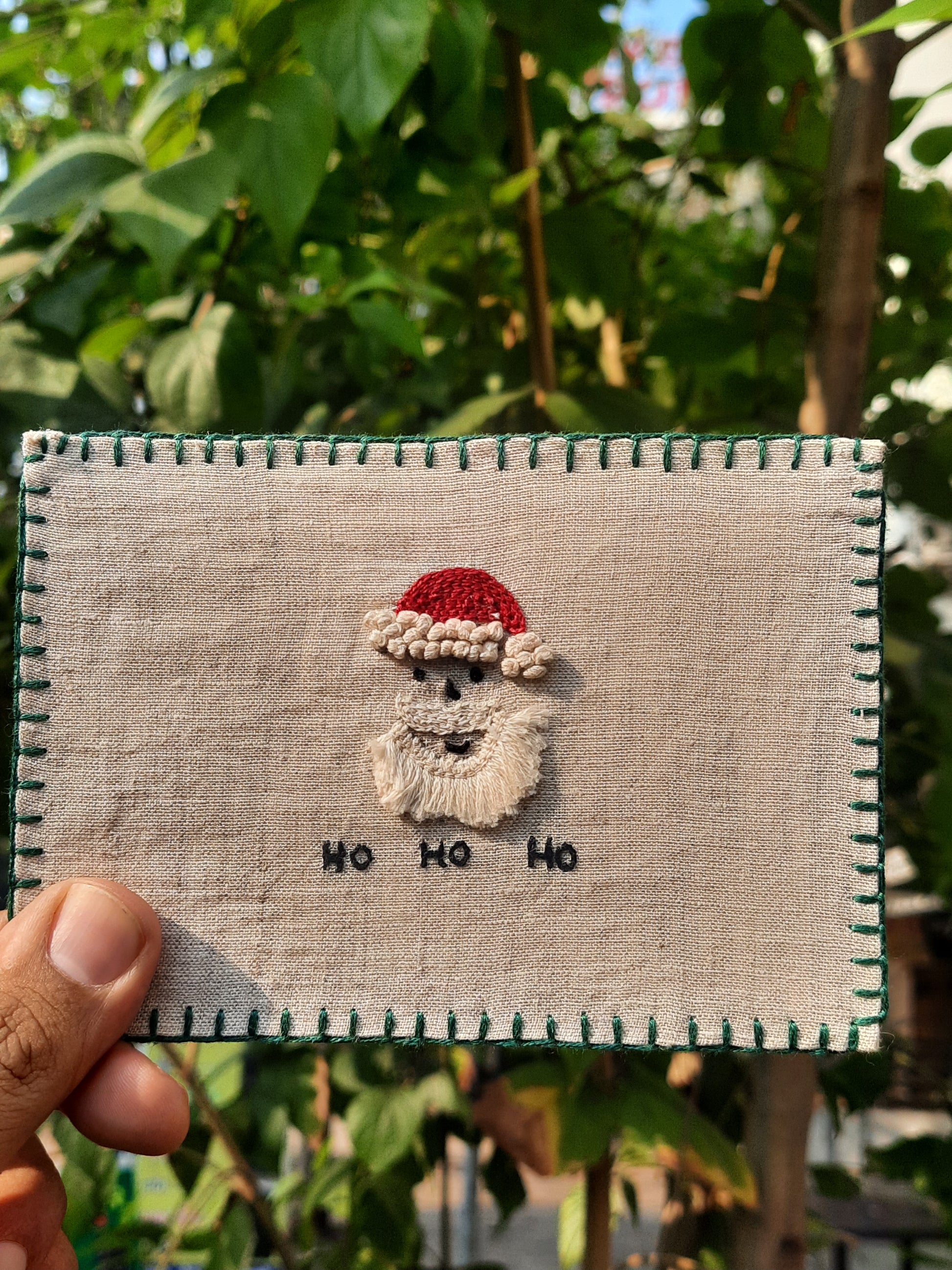 Hand-embroidered postcard featuring a festive Santa Claus design, crafted from sustainable linen, ideal for holiday greetings