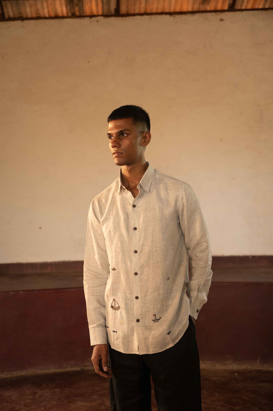 A man in eco-friendly, boats and ships hand-embroidered linen shirt in a yoga hall. Full sleeve shirt, Material: linen, front view