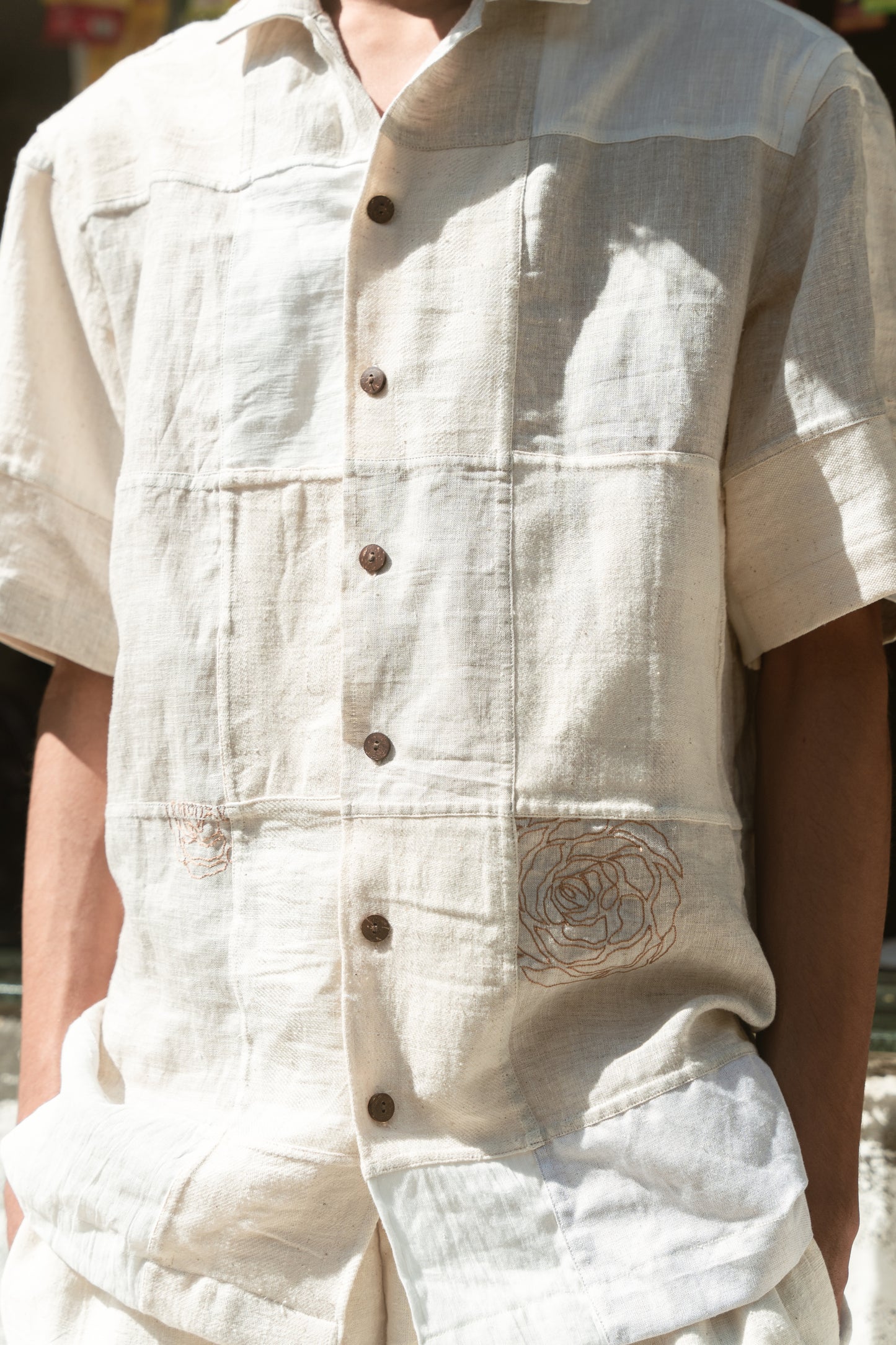 Details of an off-white half-sleeved shirt made with patches of cotton and linen squares