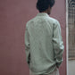 Back shot of man in mint-green pure linen full-sleeved shirt is standing in front of a pink wall