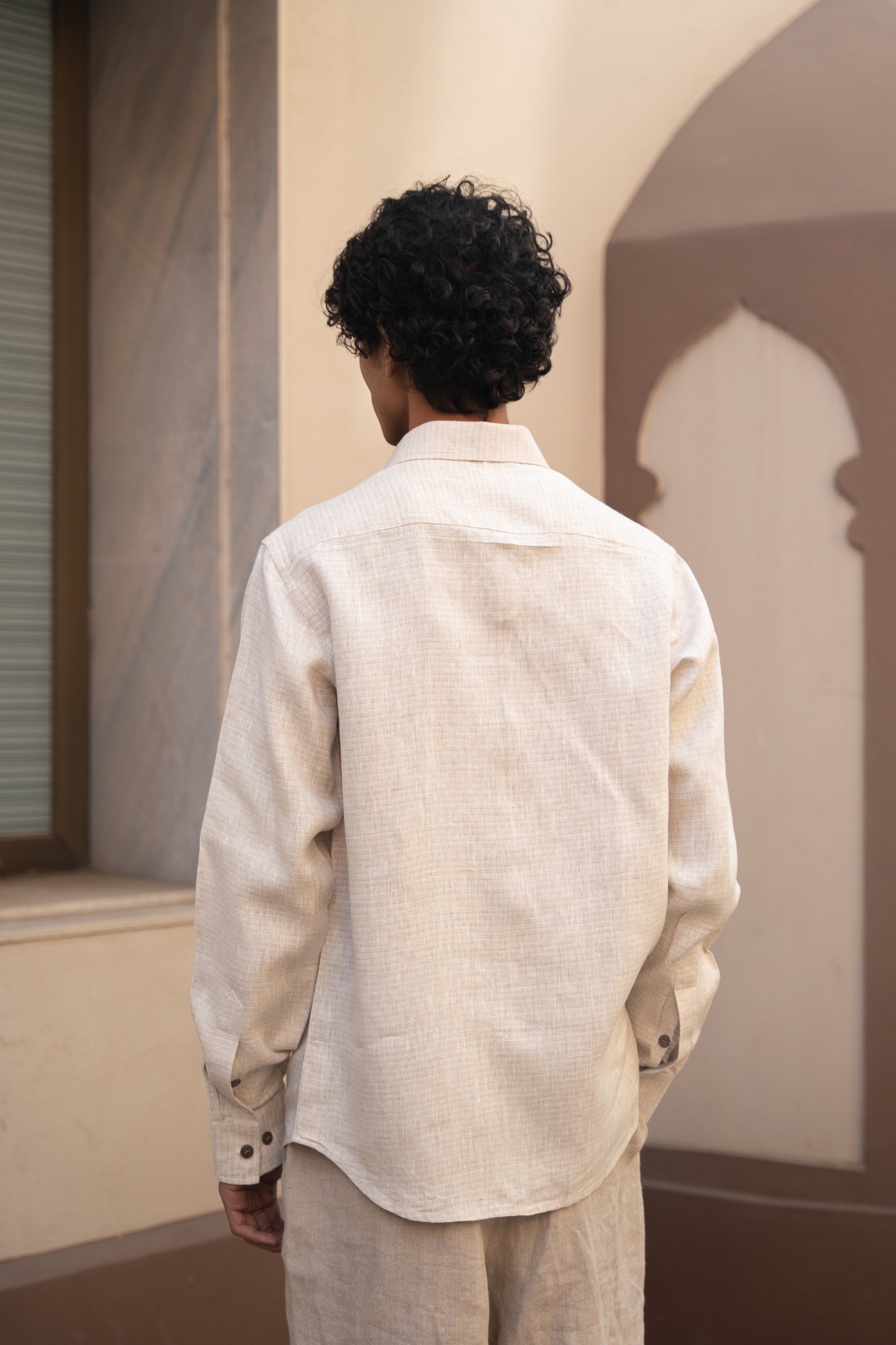 Details of the back of a man in light beige full sleeved pure linen shirt