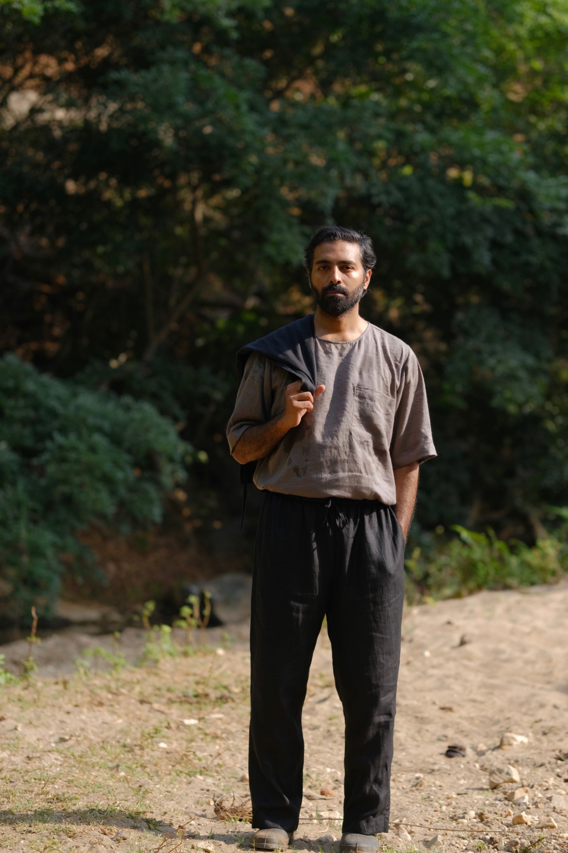 man in a grey linen T-shirt standing in a field