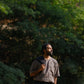 closer look of a man in a grey linen T-shirt standing in a field