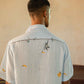 A man in eco-friendly, monkey business hand-embroidered linen shirt in a yoga hall. half sleeves shirt, Material: linen, back view