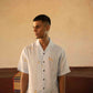 A man in eco-friendly, monkey business hand-embroidered linen shirt in a yoga hall. half sleeves shirt, Material: linen, front view