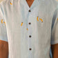 A man in eco-friendly, monkey business hand-embroidered linen shirt in a yoga hall. half sleeves shirt, Material: linen, front view