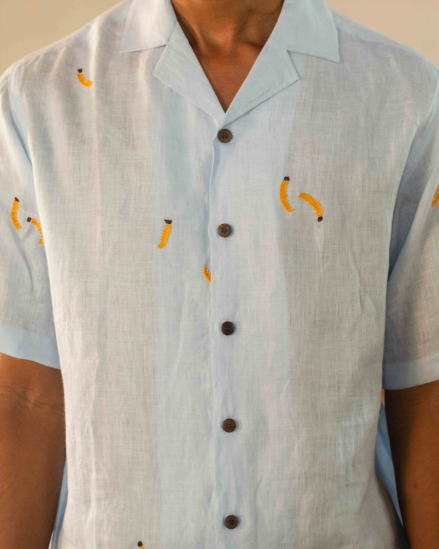 A man in eco-friendly, monkey business hand-embroidered linen shirt in a yoga hall. half sleeves shirt, Material: linen, front view