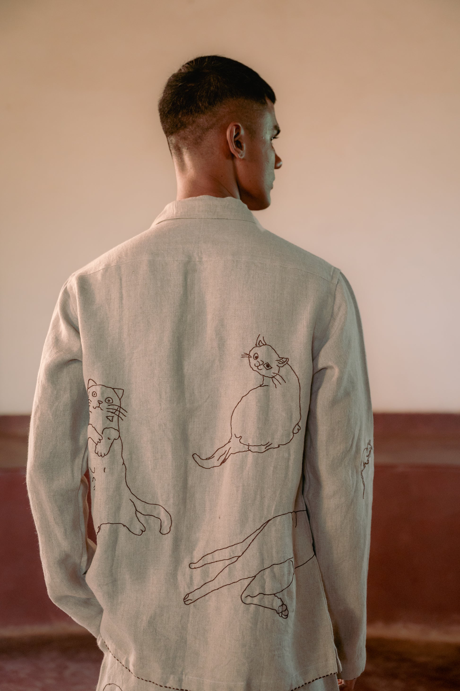 A detailed back view of a man in eco-friendly, Cats hand-embroidered linen shirt. Full sleeve shirt, Material: linen, Back view.