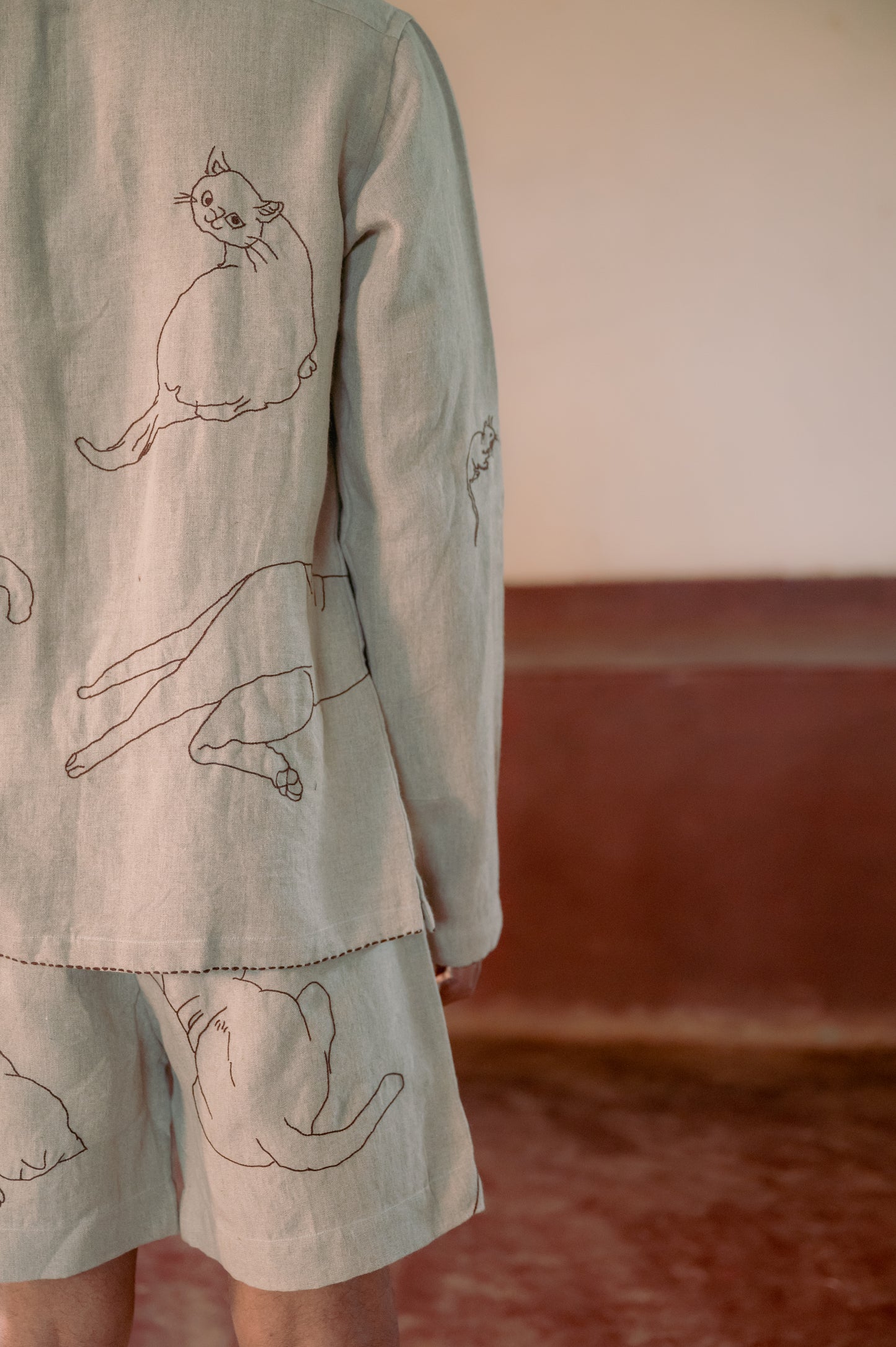 A detailed left side view of a man in eco-friendly, Cats hand-embroidered linen shirt. Full sleeve shirt, Material: linen, Back view