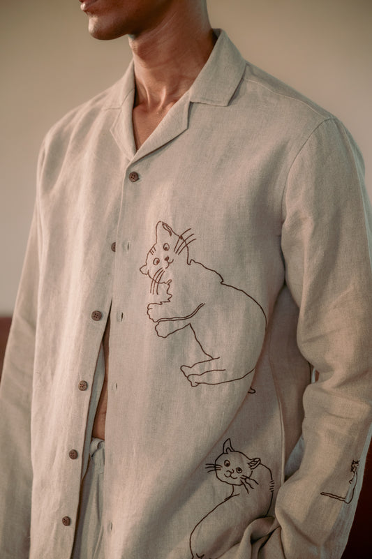 A detailed view of a man in eco-friendly, Cats hand-embroidered linen shirt. Full sleeve shirt, Material: linen.