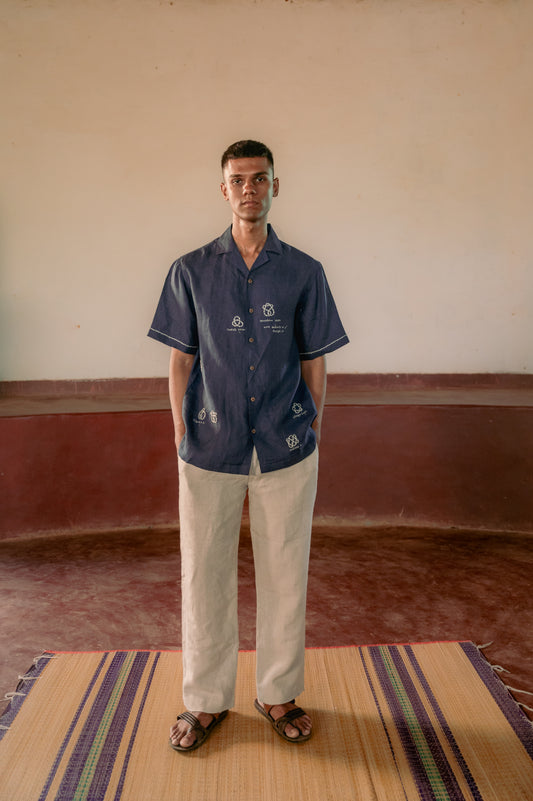 man in eco-friendly linen shirt with different knots embroidered is standing in a yoga hall. Half sleeve shirt, Material: Linen, Front view