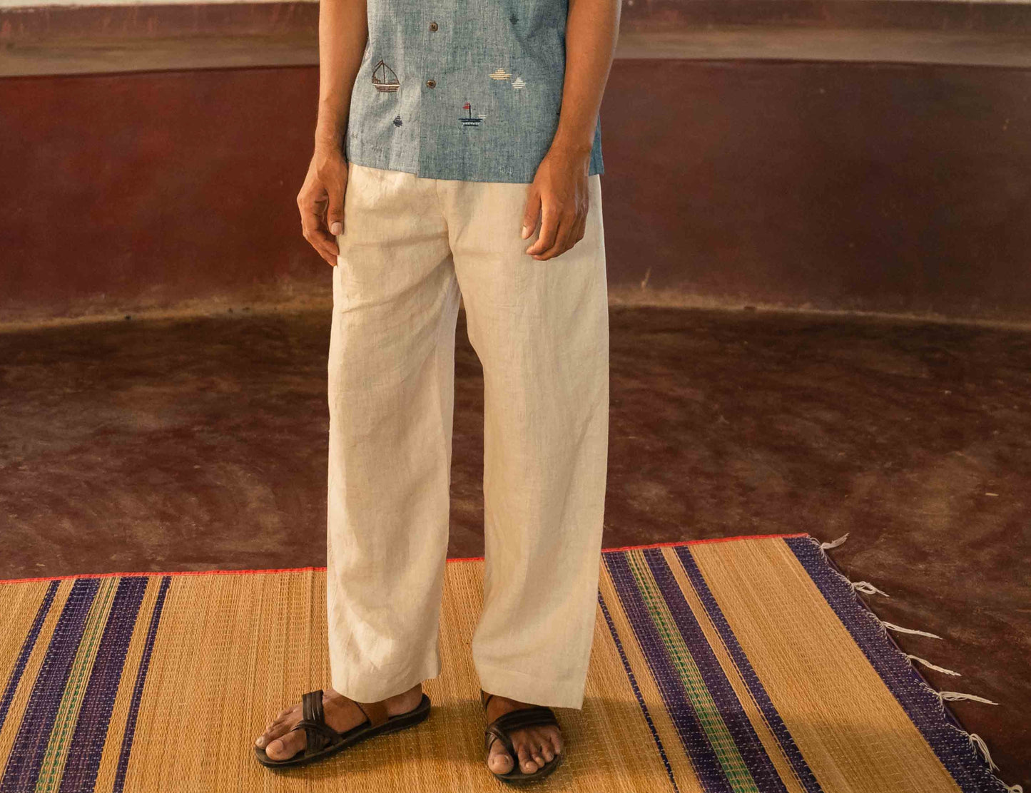 Front view of a man standing in a yoga hall wearing linen lounge pants with drawstring