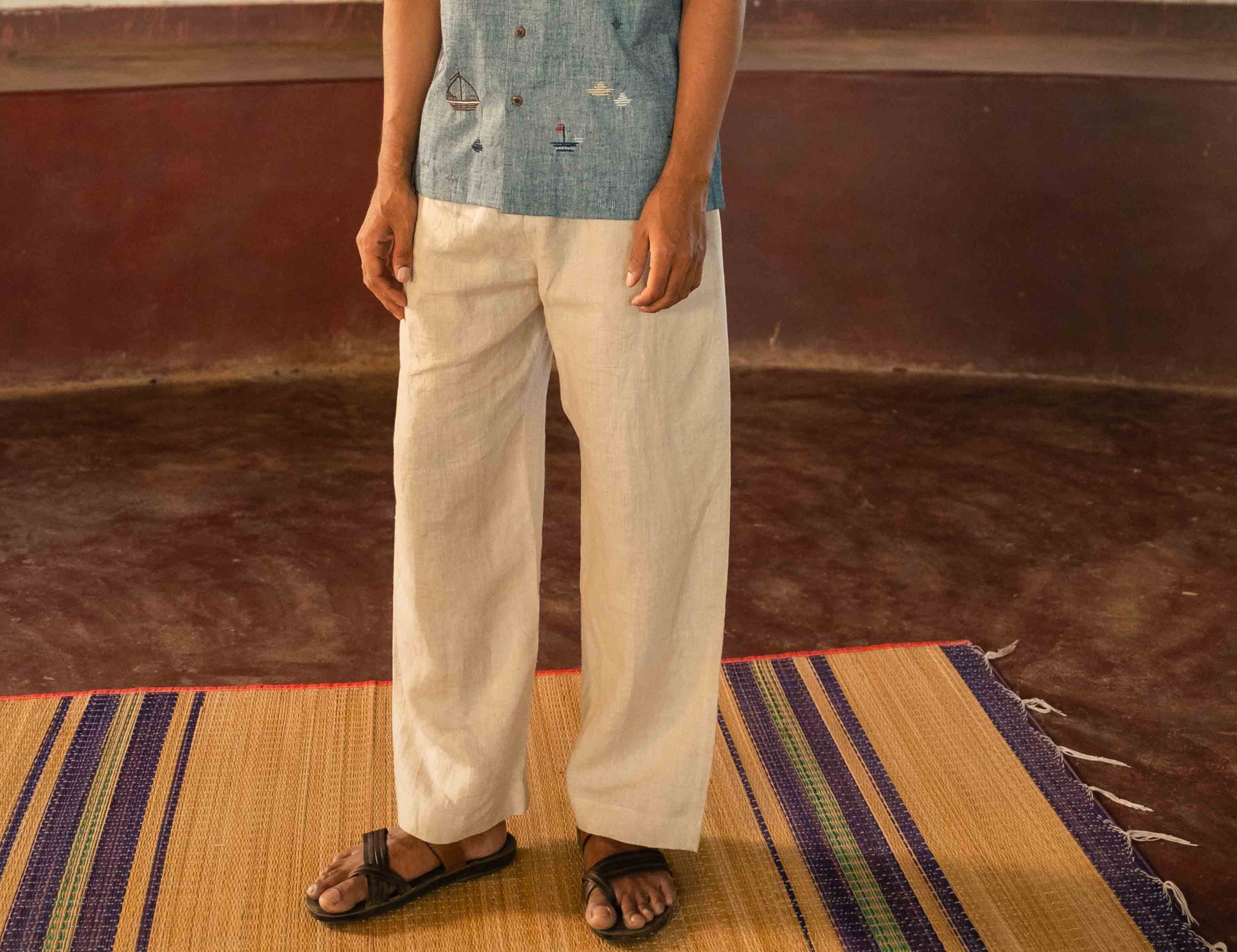 Front view of a man standing in a yoga hall wearing linen lounge pants with drawstring