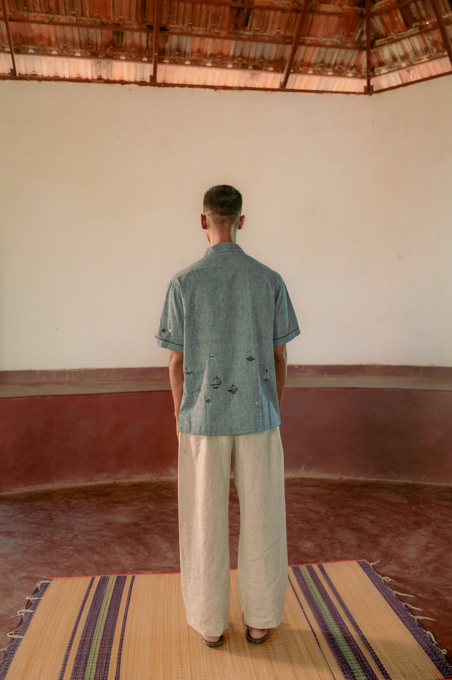 man in eco-friendly hand woven cotton shirt standing in a yoga hall. Half sleeve shirt, Material: cotton, Back view