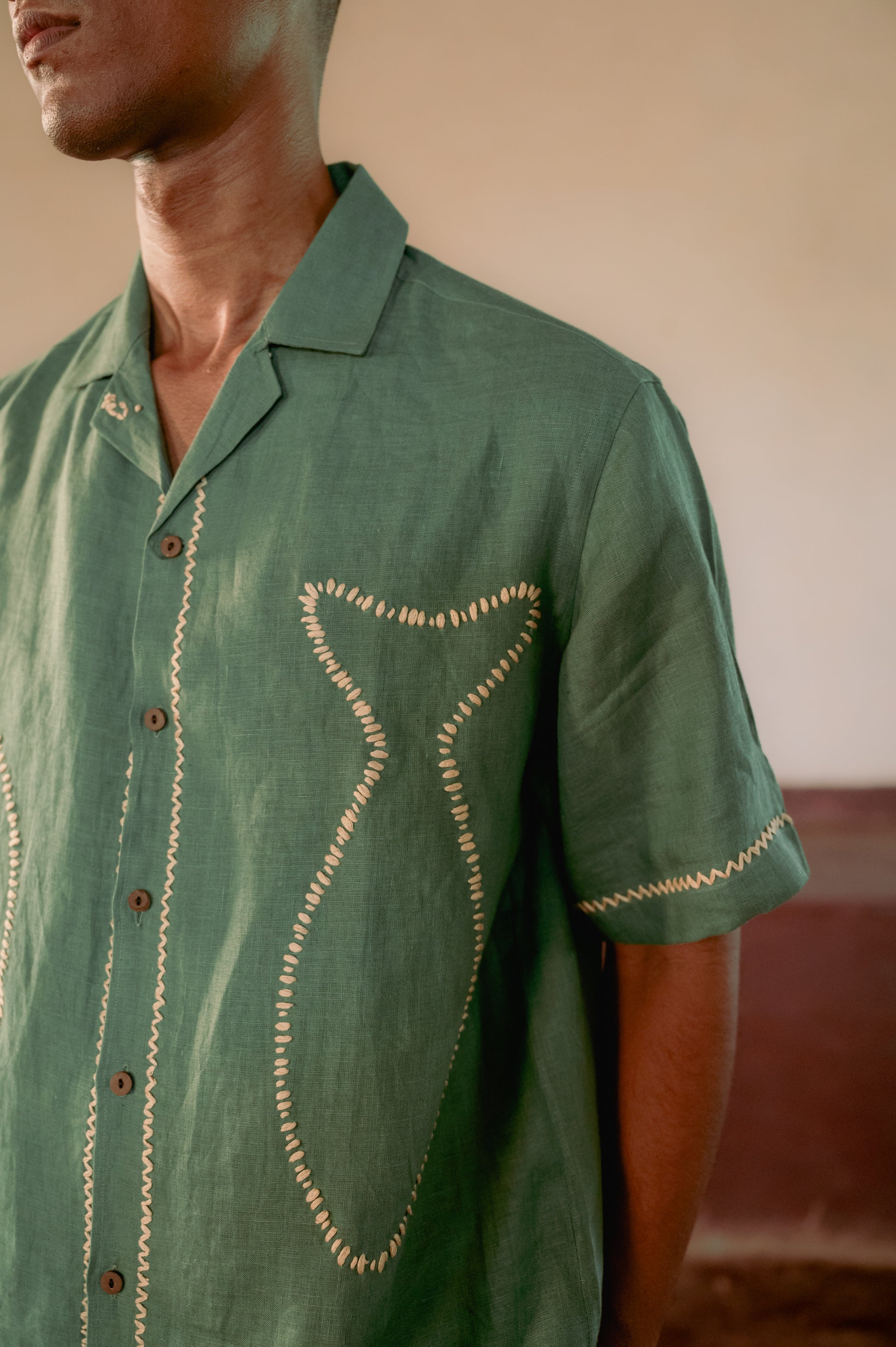 Details of the fish outline in the classy kantha style on a green linen half-sleeved shirt