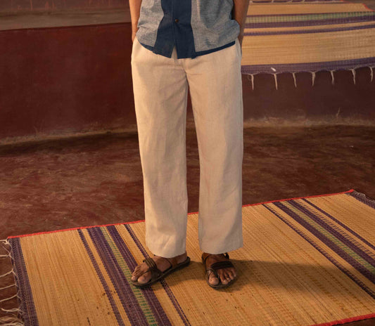 A man standing in a yoga hall wearing dark beige linen lounge pants. Front view