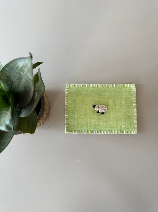 Hand-embroidered postcard featuring a unique green sheep design on sustainable linen, perfect for gifting or collecting.