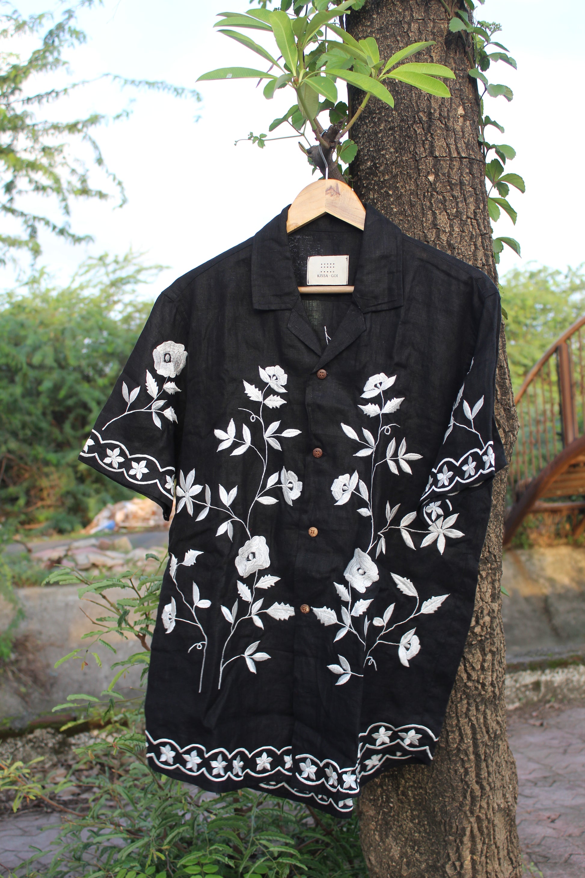 Front view of  a black linen half sleeved shirt with off-white floral embroidery