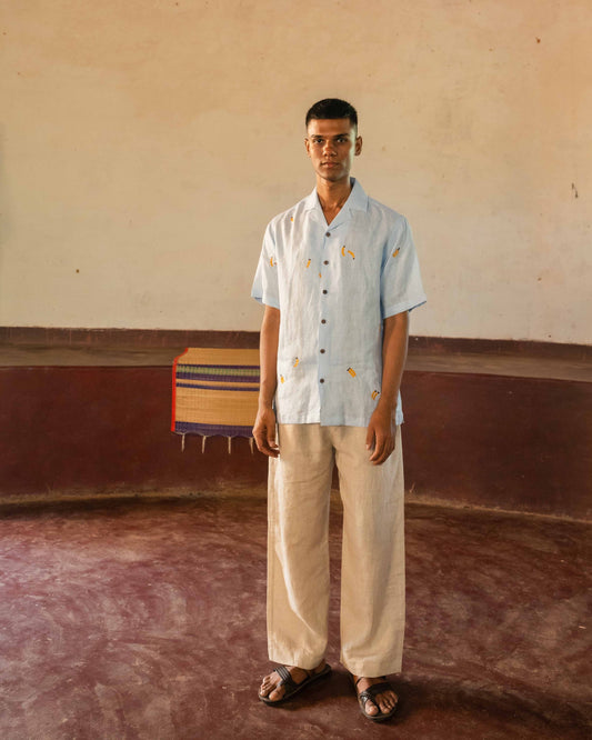 A man in eco-friendly, monkey business hand-embroidered linen shirt in a yoga hall. half sleeves shirt, Material: linen, front view.