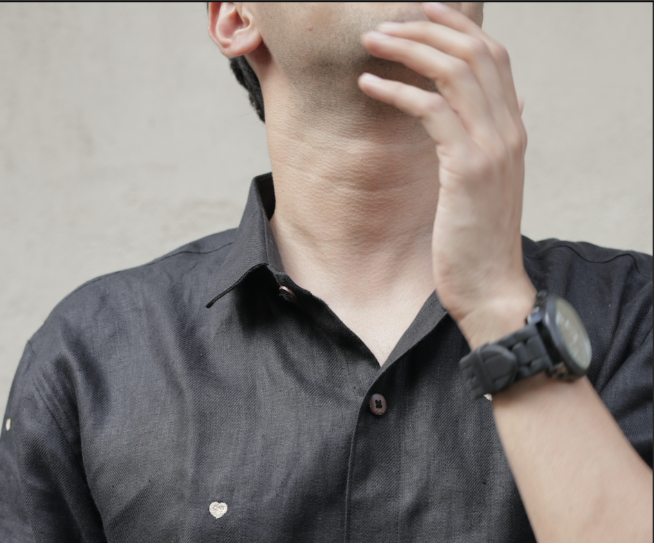 Collar details of a black linen full-sleeved shirt with tiny embroidered hearts