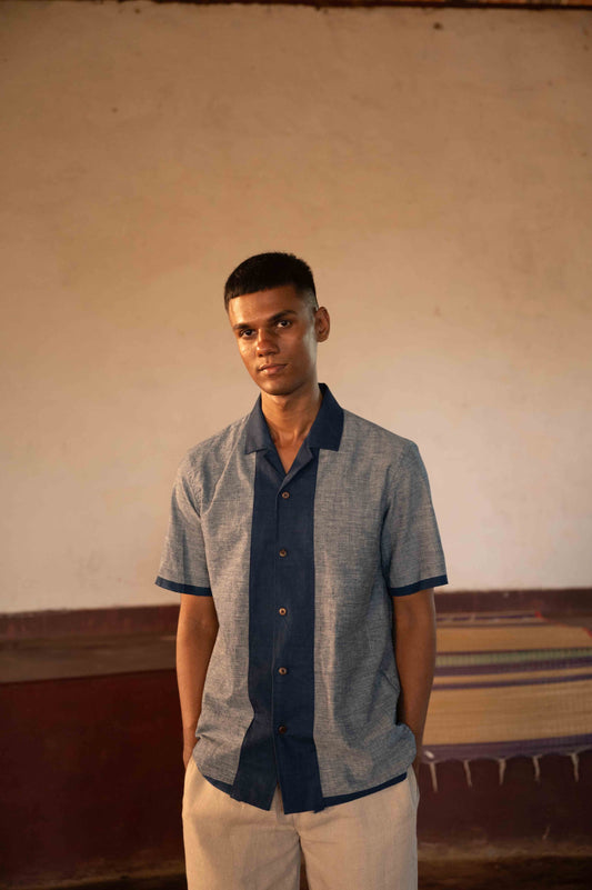 A man in eco-friendly, shades of blue patchwork cotton shirt in a yoga hall. half sleeves shirt, Material: cotton, front view