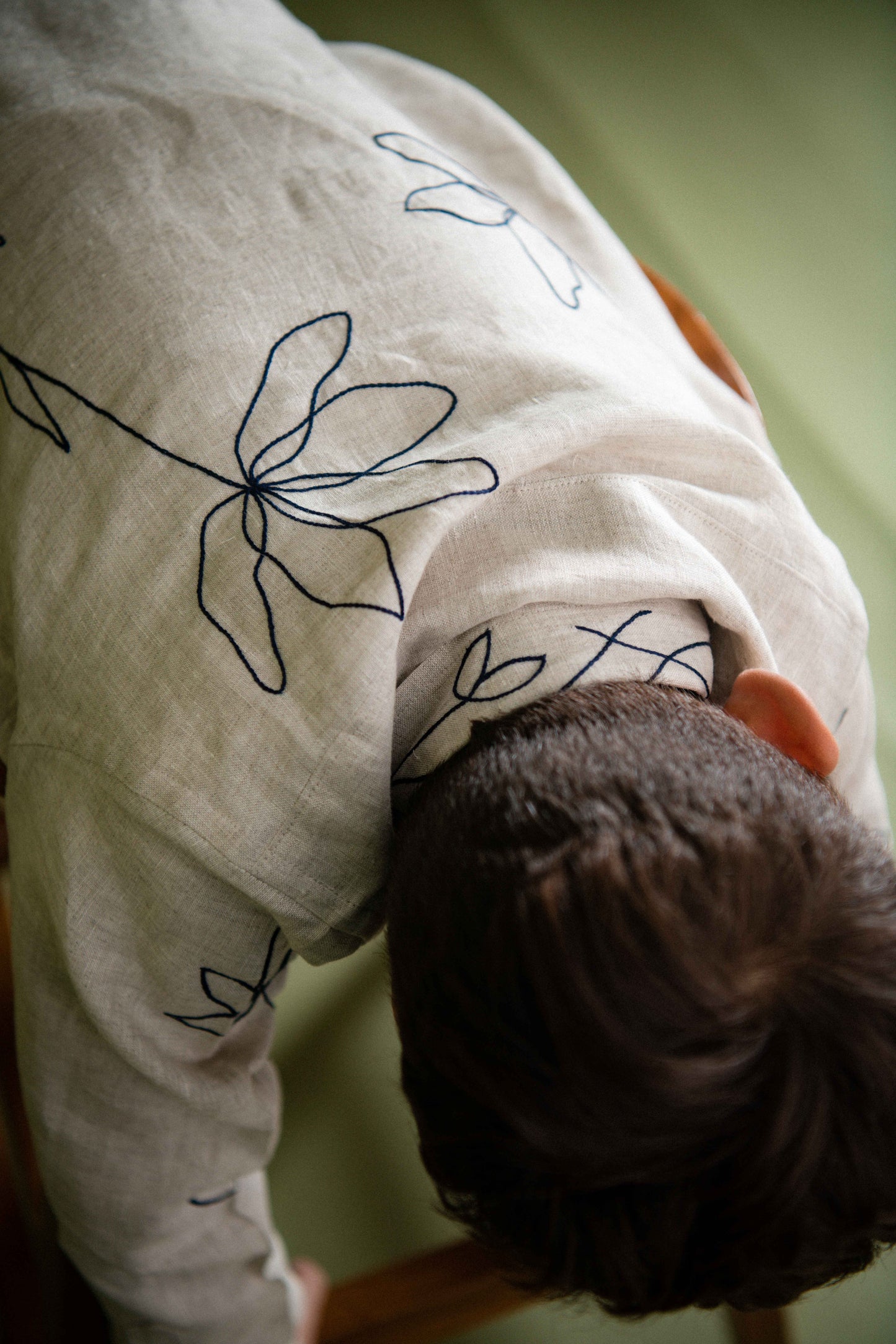 Embroidery and collar details of a beige linen shirt