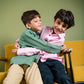 two boys in green and pink linen shirt playing with each other