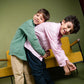 two boys in green and pink linen shirt playing with each other