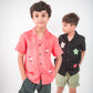 Two young boys in red and black linen shirt with roosters and flowers embroidered respectively