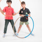 two boys in red and black linen shirts respectively playing with hulahoops