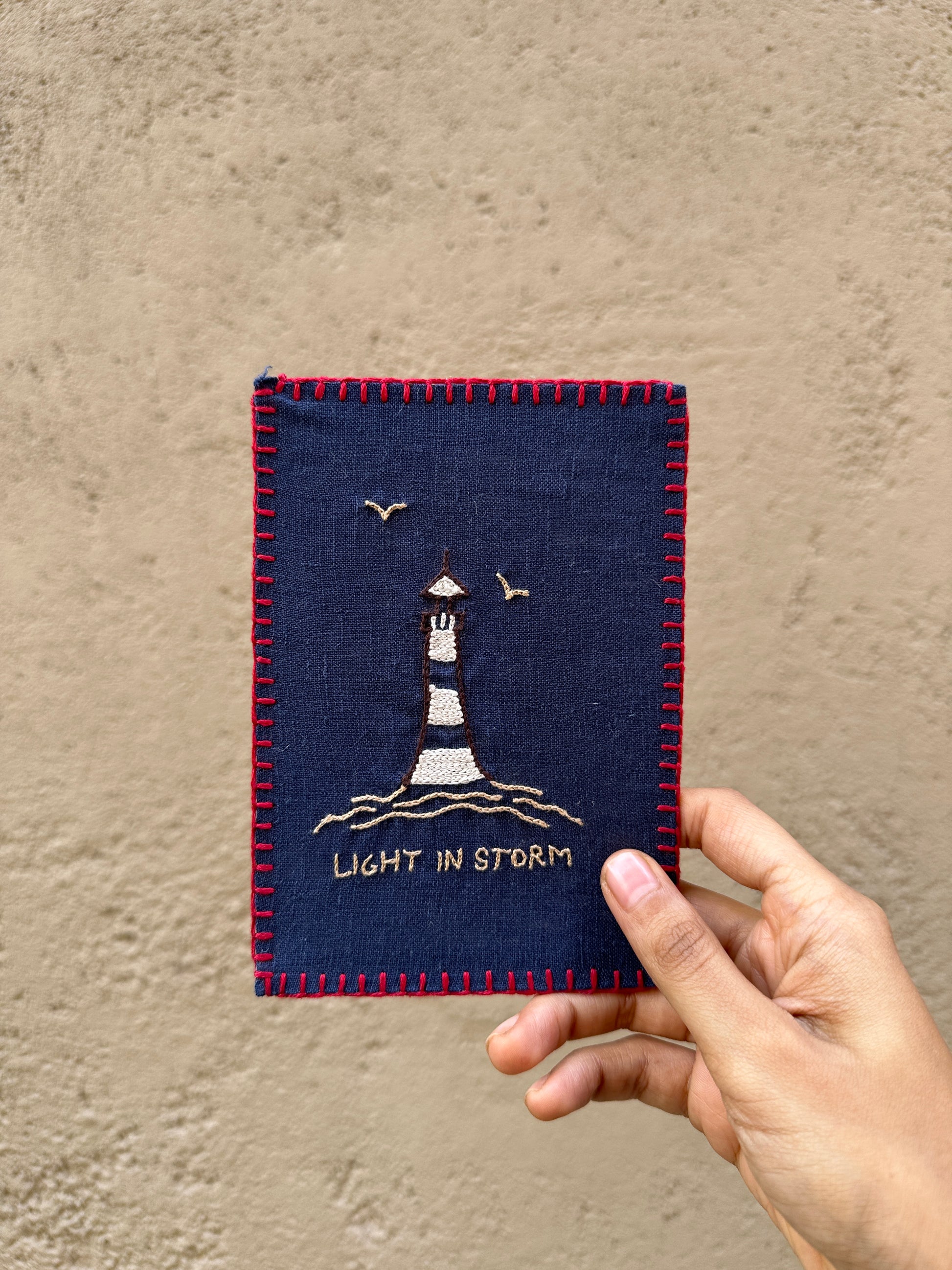 Hand-embroidered postcard featuring a lighthouse design, symbolizing guidance and support during challenging times, crafted from sustainable linen