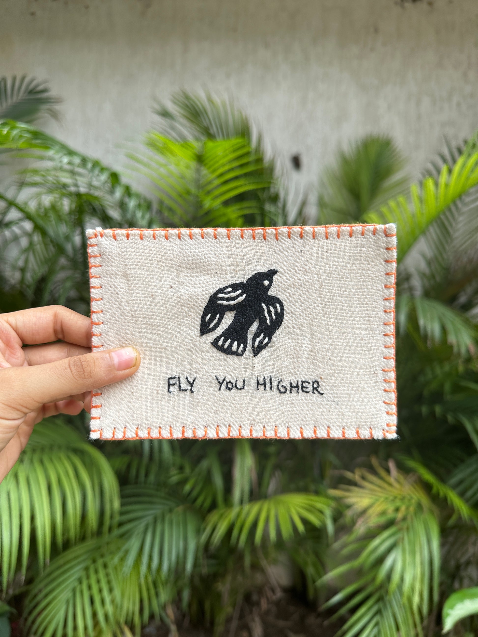 Hand-embroidered postcard featuring a soaring bird and the phrase 'Fly You Higher,' crafted from sustainable linen, ideal for inspiring greatness