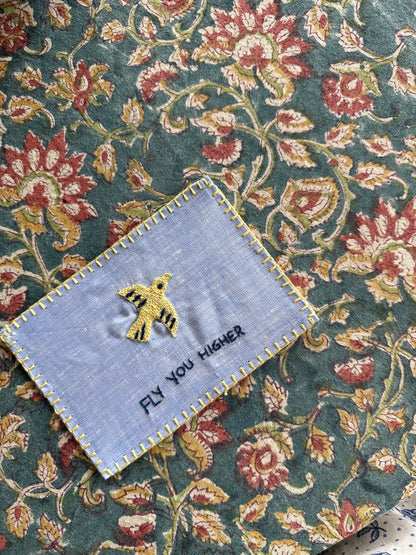 Hand-embroidered postcard featuring a soaring bird and the phrase 'Fly You Higher,' crafted from sustainable linen, ideal for inspiring greatness