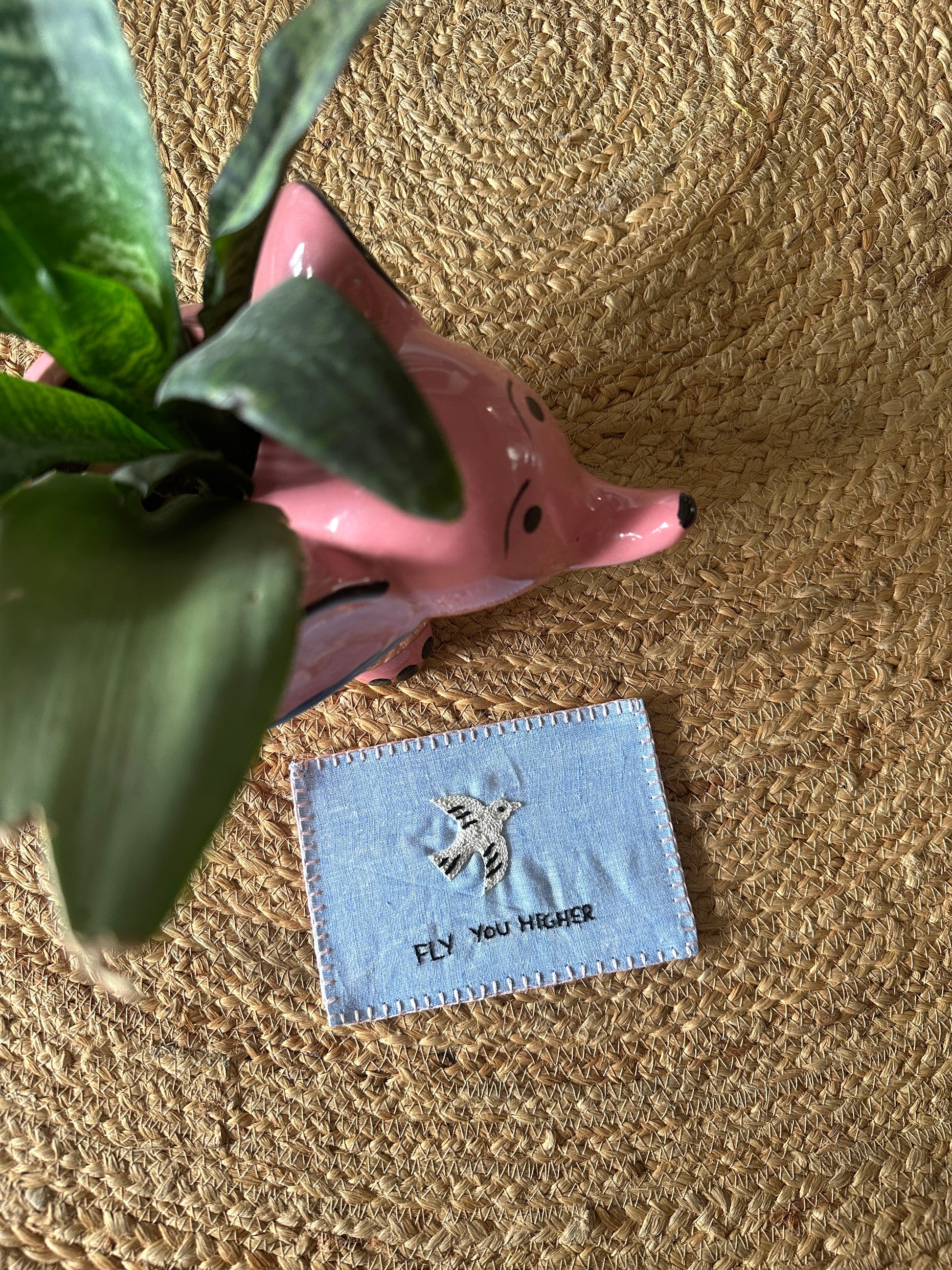 Hand-embroidered postcard featuring a soaring bird and the phrase 'Fly You Higher,' crafted from sustainable linen, ideal for inspiring greatness