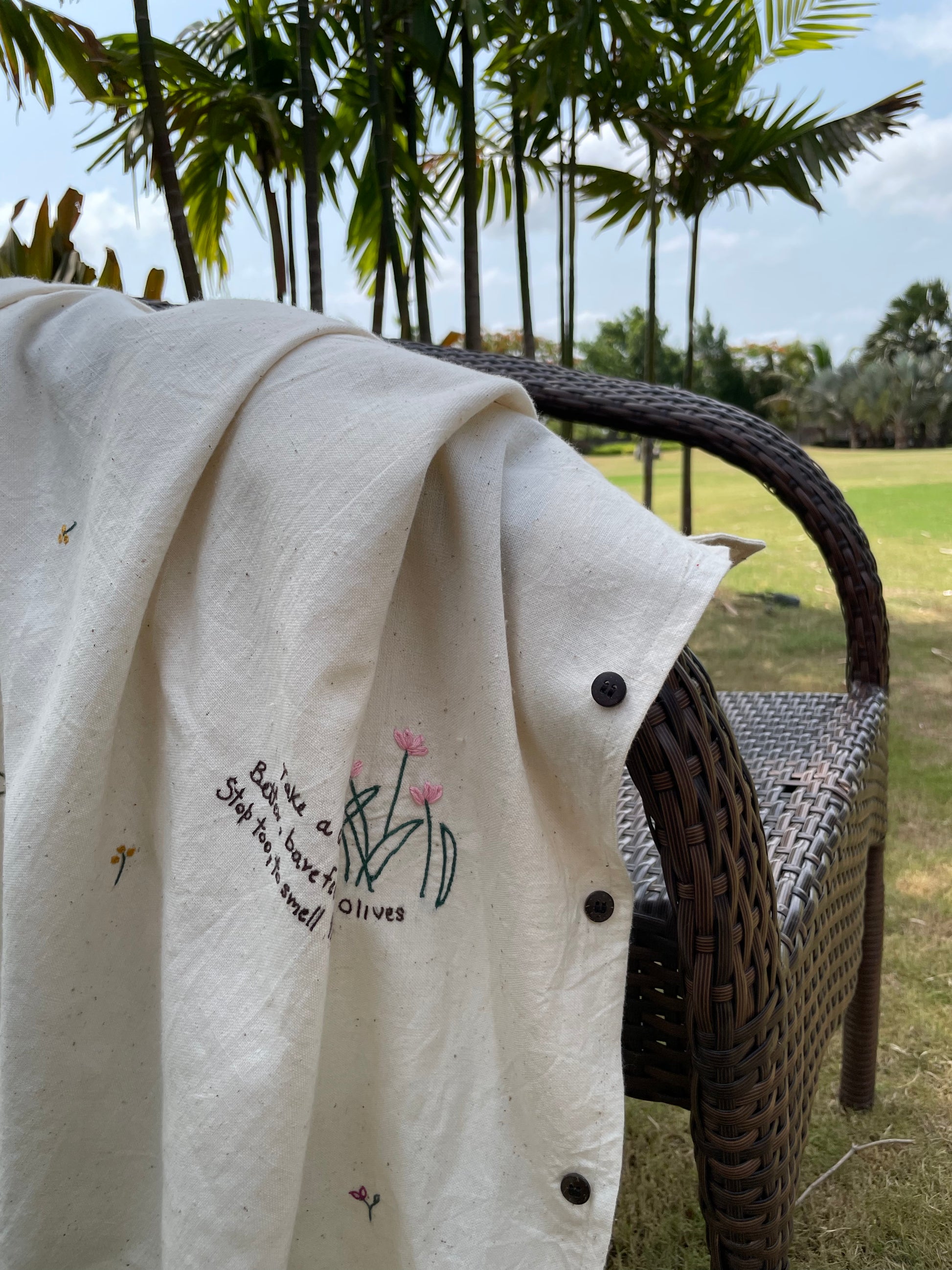 flat lay of an off-white half sleeved shirt with a beautiful quote hand-embroidered