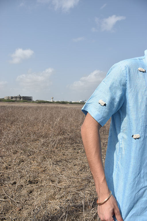 Detail of a Blue Half sleeve shirt with white colored sheep embroidered randomly