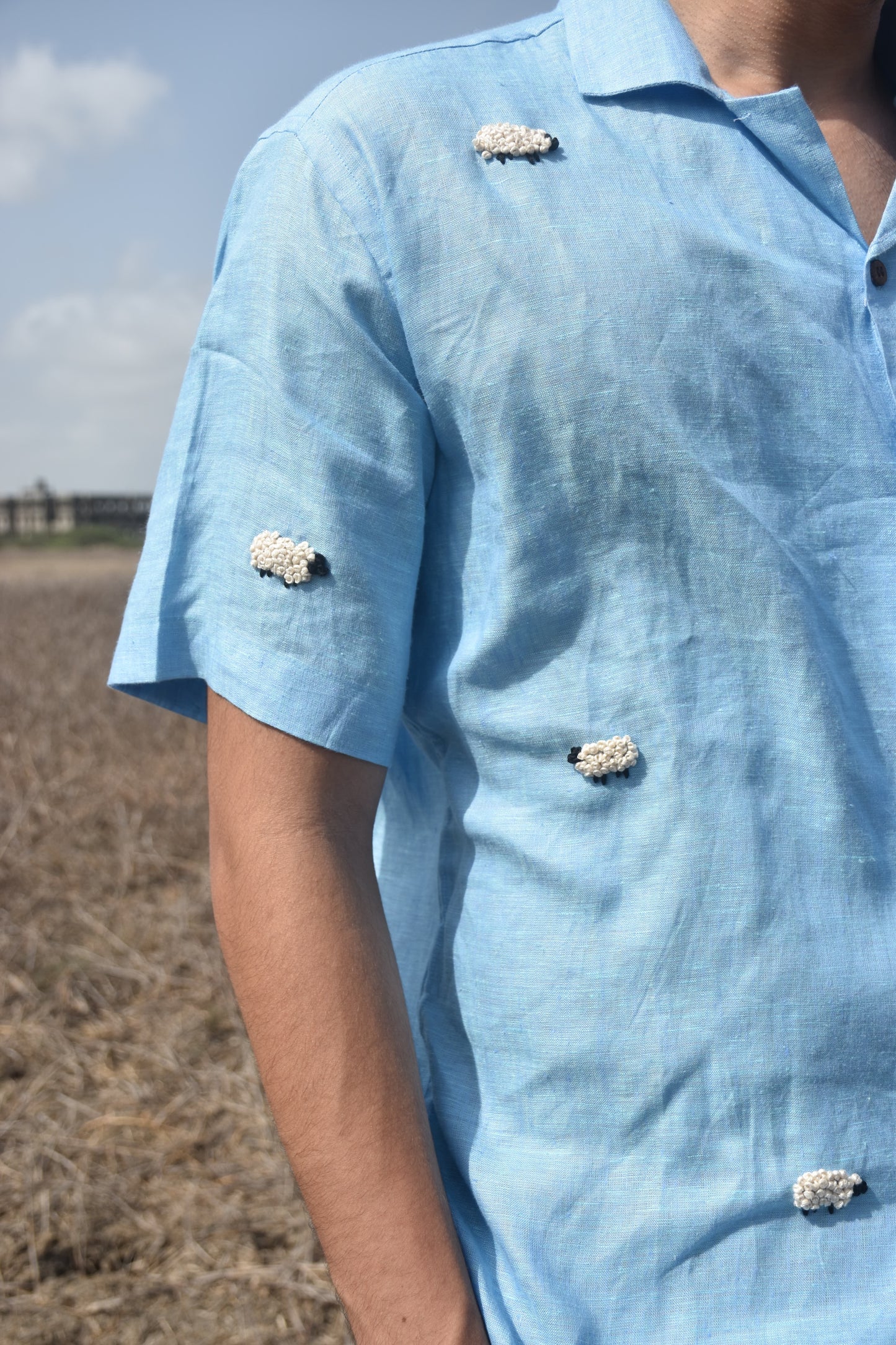 Detail of a Blue Half sleeve shirt with white colored sheep embroidered randomly