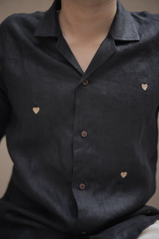 Details of a black linen shirts with tiny embroidered hearts 