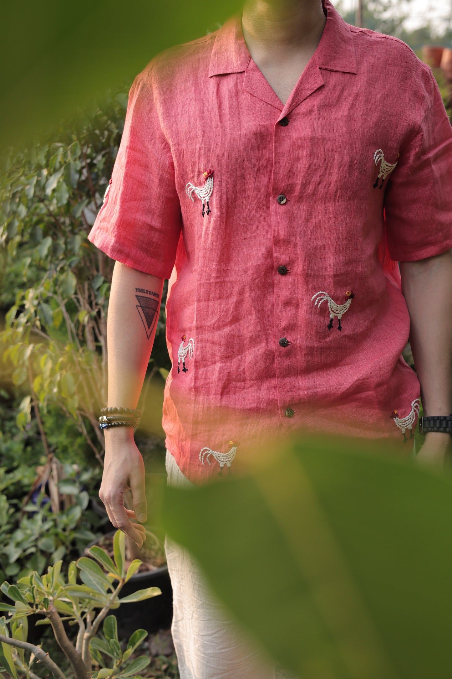 Front details of a beautiful red linen shirt with hand-embroidered roosters