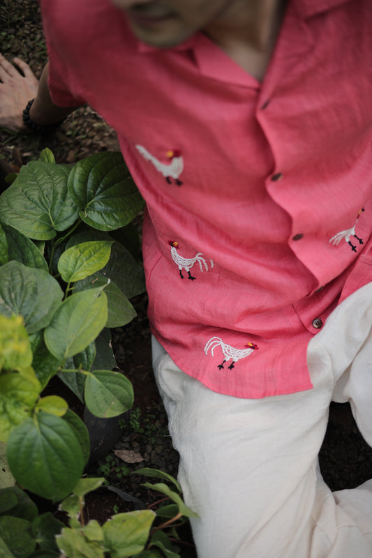 Details of a beautiful red linen shirt with hand-embroidered roosters