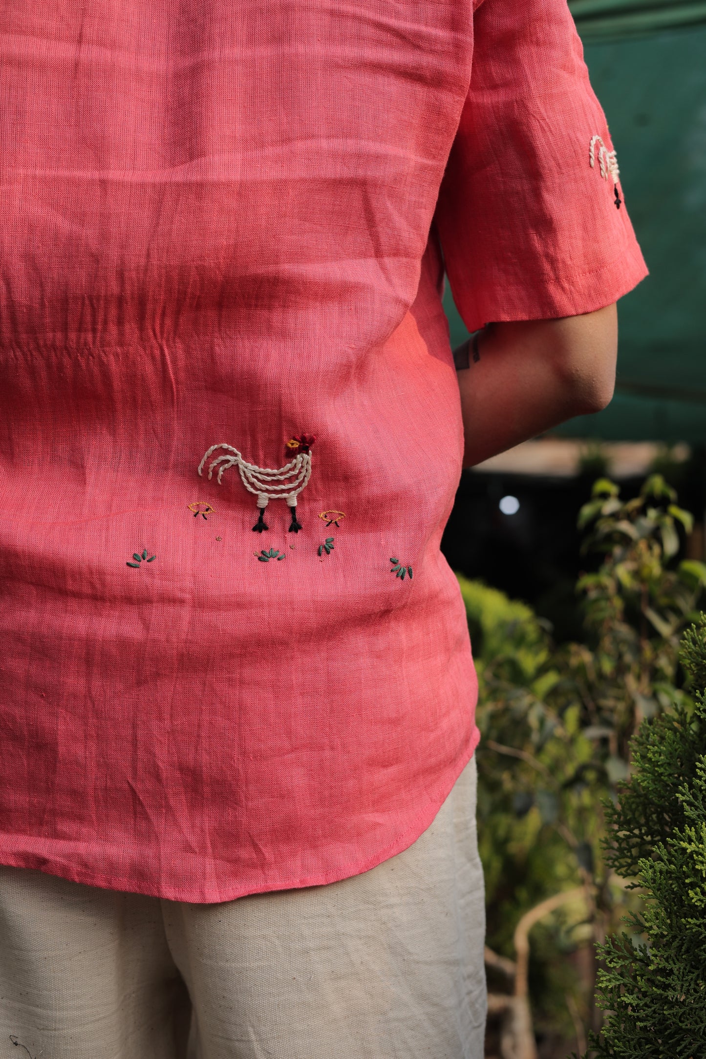 Back details of a beautiful red linen shirt with hand-embroidered roosters