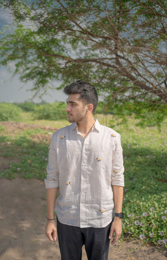 man in eco-friendly linen sheep shirt standing in a lush green field. Black sheep, Long sleeve shirt, Material: Linen, Front view