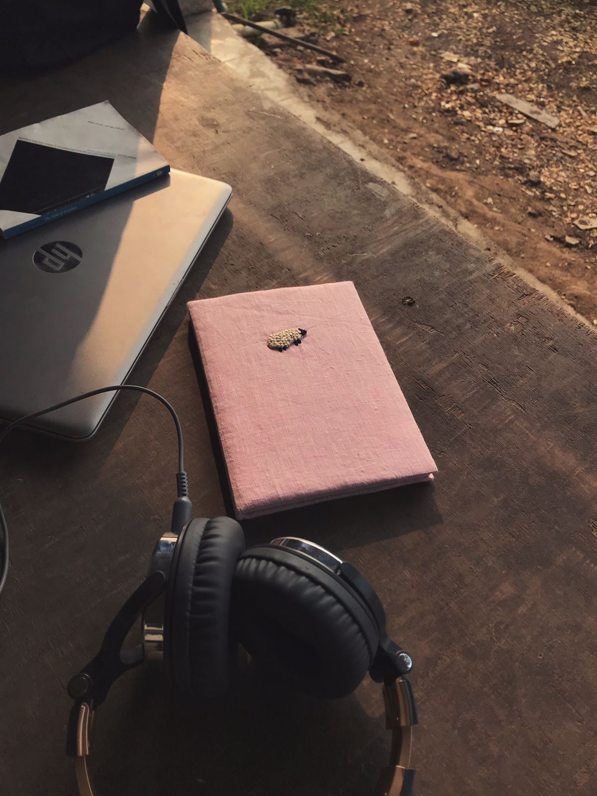 A pink cover diary made with pink linen scraps with a white sheep embroidered on the cover